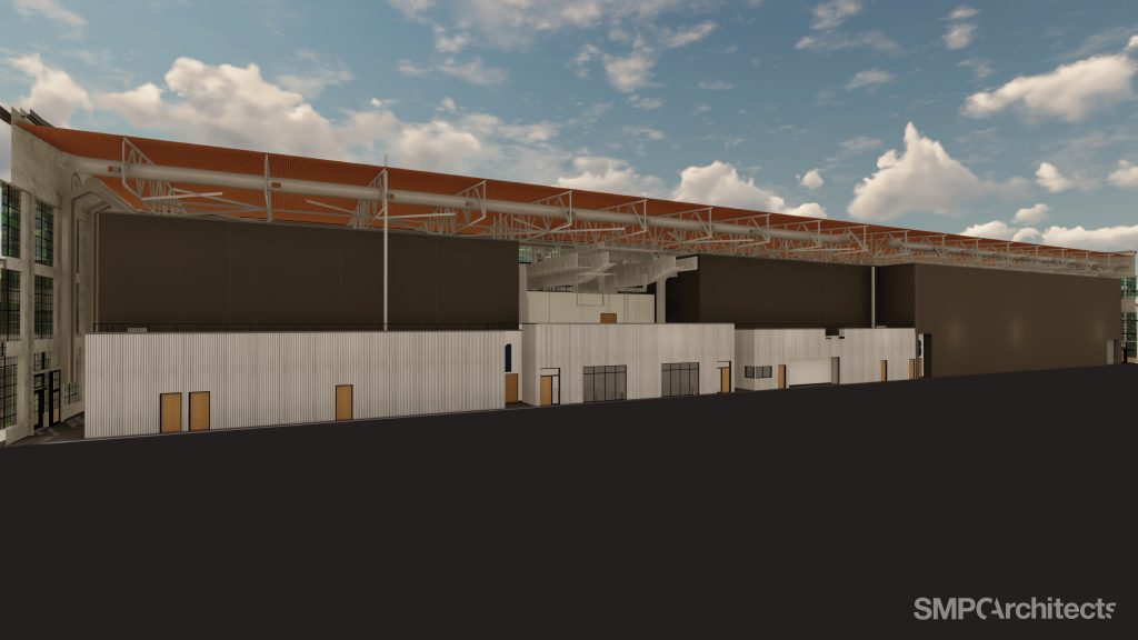 Digital rendering of a large industrial building with a red roof and dark wall panels.
